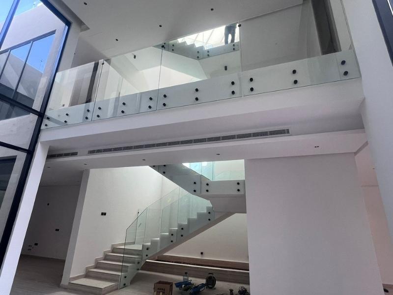 premium frameless glass railing for indoor staircase and balcony in a luxury riyadh villa.